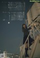 A woman standing on the steps of a building at night.