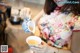 A woman pouring tea into a cup in a kitchen.