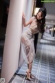 A woman leaning against a wall in a hallway.