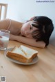 A woman laying on a table next to a plate of food.