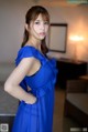 A woman in a blue dress posing for a picture.