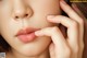 A close up of a woman's face with her hand on her chin.