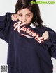 A woman in a blue sweatshirt with the word Kickwork on it.