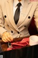 A woman in a suit and tie sitting at a table.