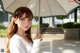 A woman holding an umbrella in front of a building.