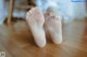 A pair of bare feet on a wooden floor.