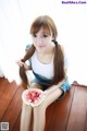 A woman sitting on the floor eating a slice of watermelon.