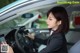 A woman sitting in a car using a cell phone.