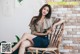 a woman sitting on top of a wooden chair