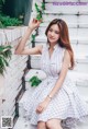 A woman in a white dress sitting on some steps.