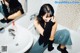 A woman sitting on a bathtub in front of a mirror.